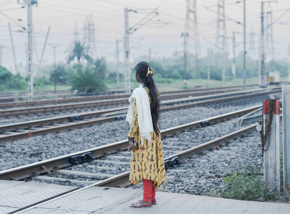 Girl standing by a railway crossing